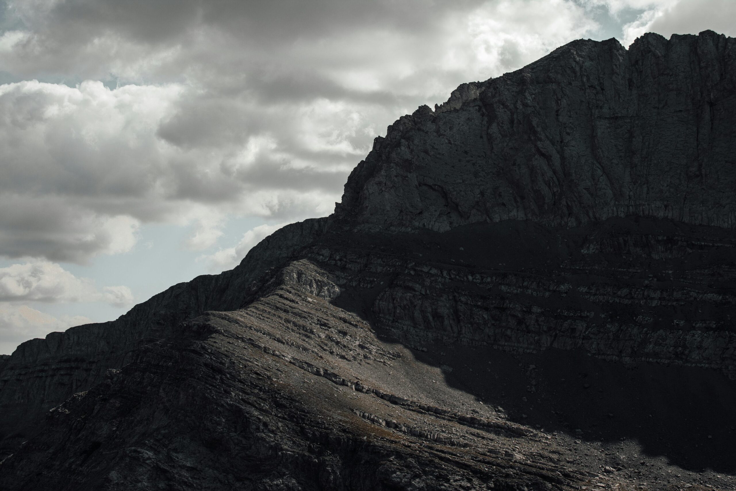 A stunning view of Mount Olympus under an overcast sky, showcasing its rugged terrain and dramatic lighting.