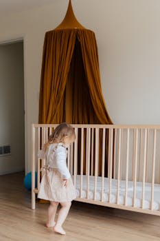 Charming child in a nursery with crib and whimsical decor. Ideal for family and childhood themes.